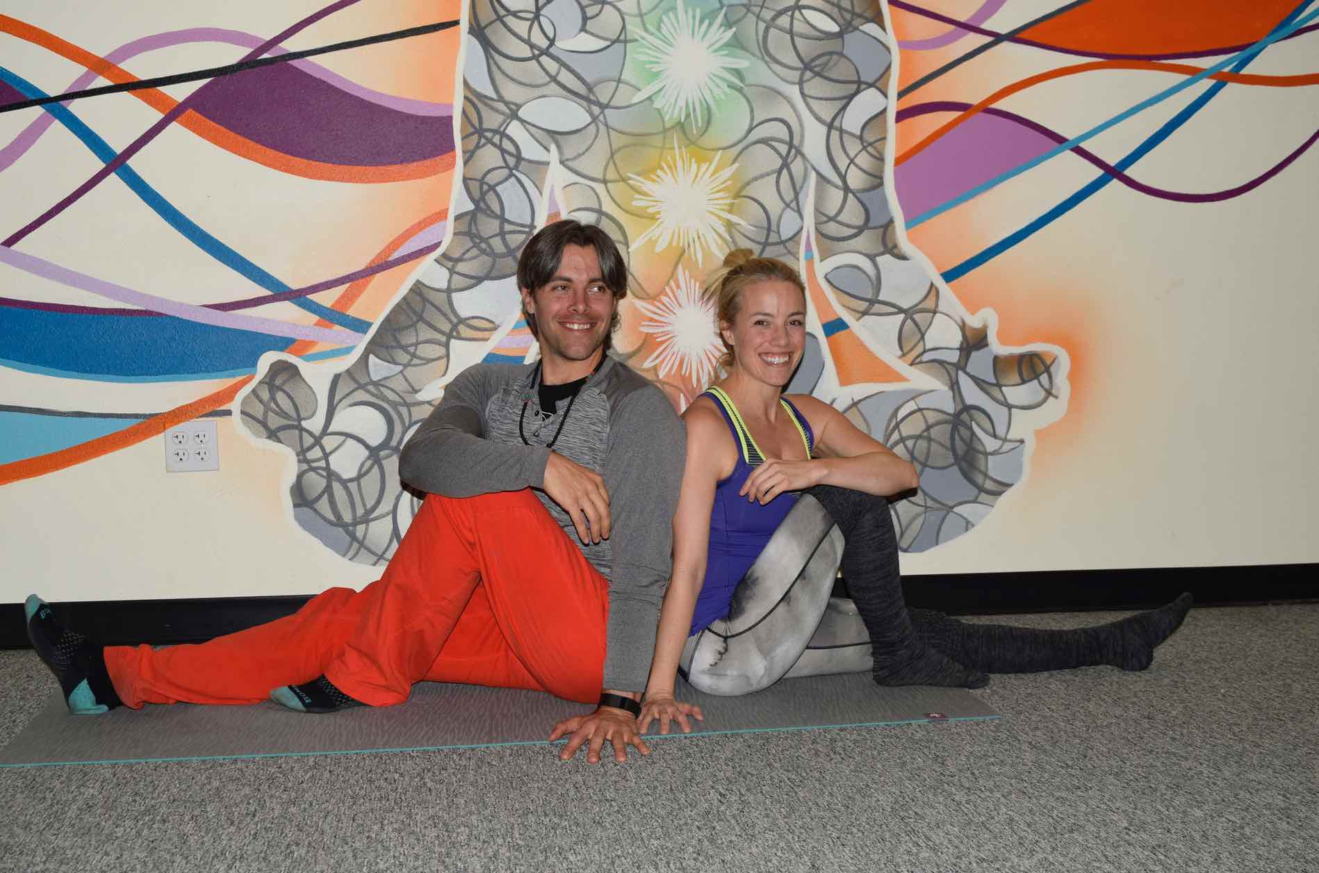 Photo of Amber and Austin Richman sitting in front of the Charka Mural