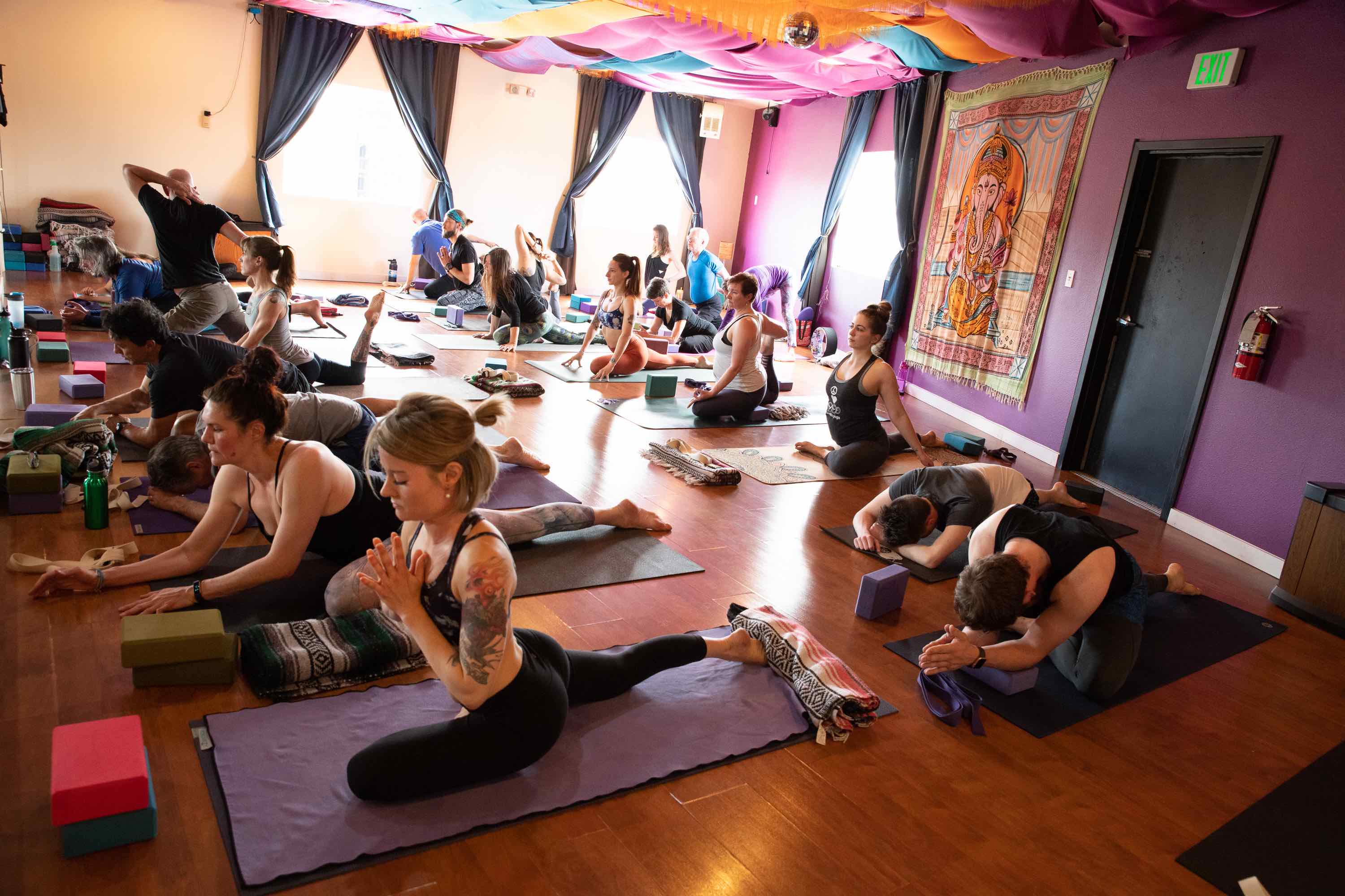 Yoga Class with students in half pigeon