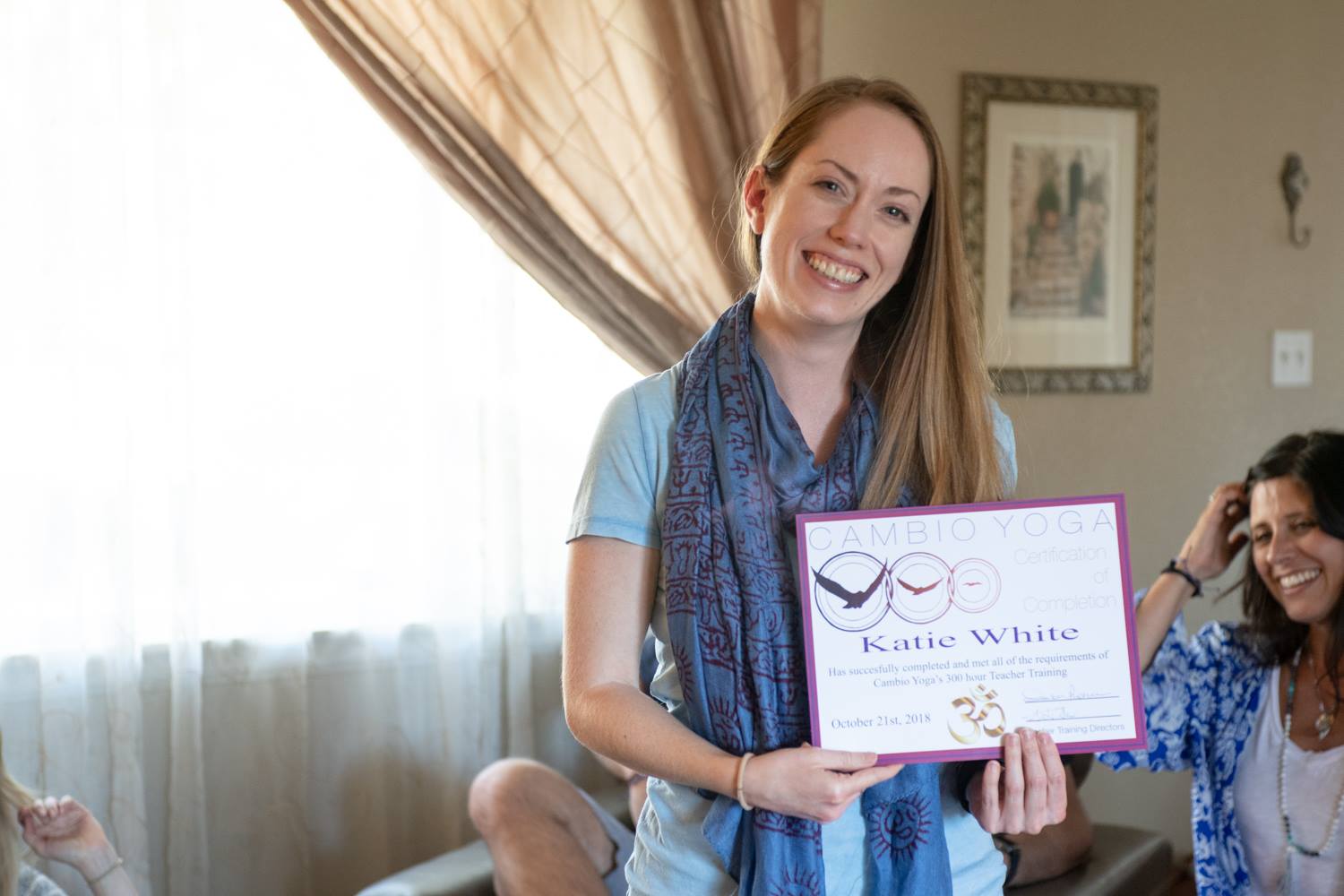 Photo of Katie holding her YTT certificate