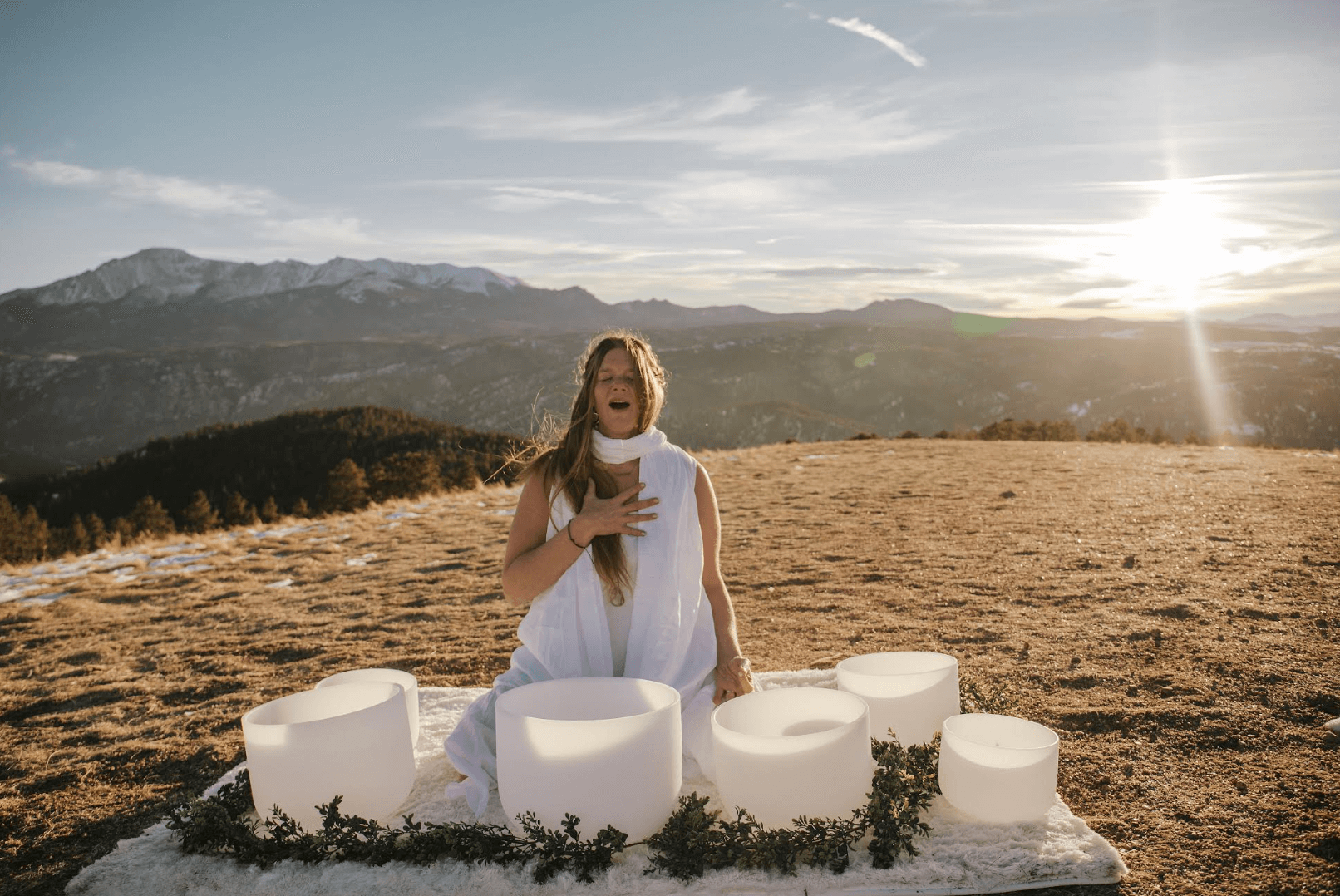 Photo of Rian sitting in an open plain with Pikes Peak in the background